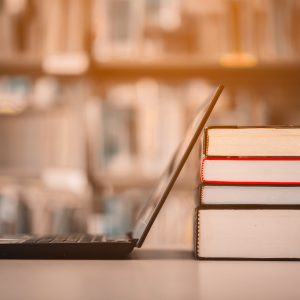 Bookshelves and laptops are placed on the library desk.E-learning class and e-book digital technology