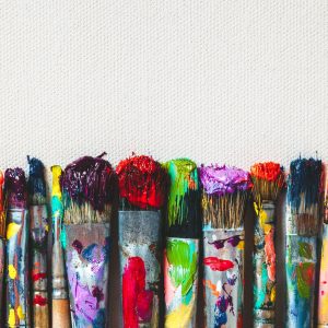 Row of artist paintbrushes closeup on artistic canvas.